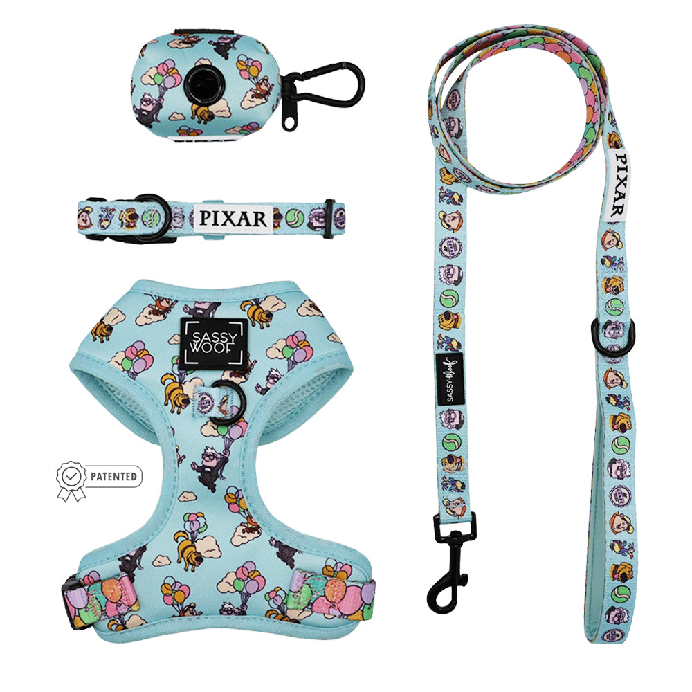 The Sassy Woof Dog Four Piece Bundle – Disney and Pixar’s Up includes an adjustable harness, leash, collar, and waste bag holder with cartoon characters and balloons on a light blue background.