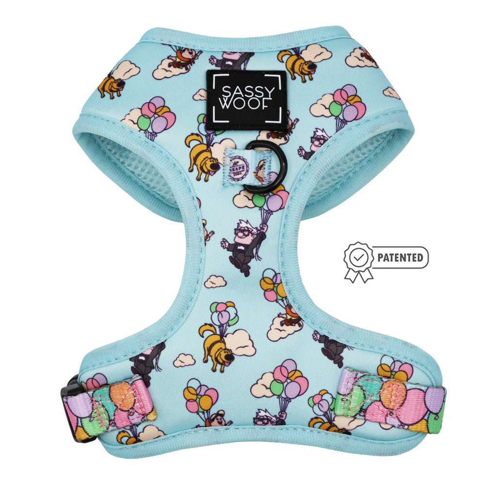 The Sassy Woof Dog Two Piece Bundle - Disney and Pixar's Up is a light blue adjustable harness with cartoon dogs floating with balloons, inspired by Pixar. It features a black Sassy Woof label on the front and a patented icon on the right.