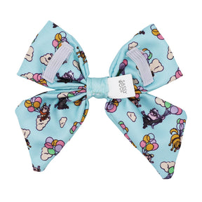 The Sassy Woof Dog Sailor Bow – Disney and Pixar's Up features colorful balloons, clouds, and dogs with balloons, plus a white logo label in the center and two lilac grosgrain ribbon accents. Perfect for fans of Disney Up dog accessories!.