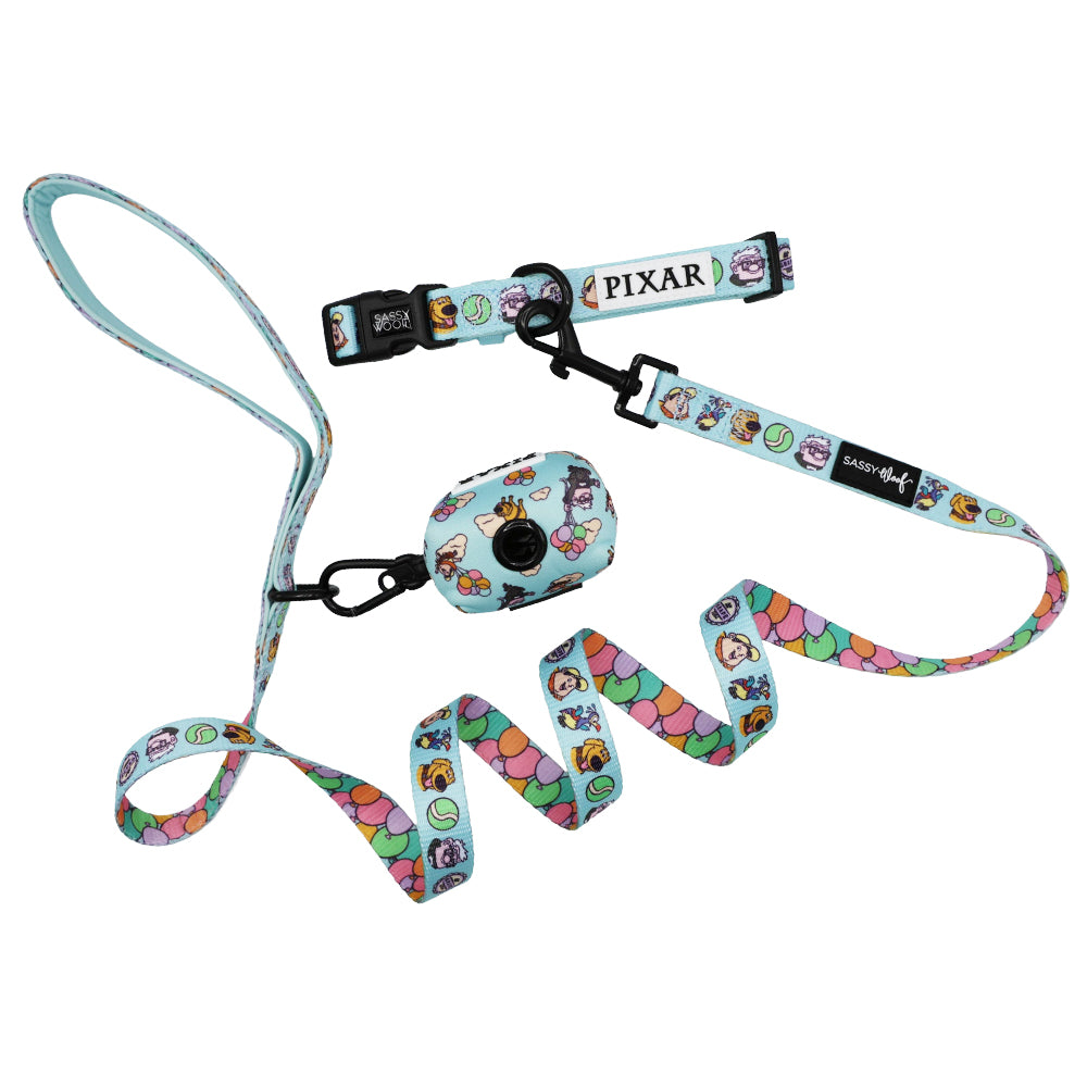 Light blue Sassy Woof Collar Three Piece Bundle – Disney and Pixar's Up, includes a dog collar, leash, and waste bag holder with colorful character faces, balloon pattern, Pixar logo tag, and black clip—ideal for Up fans!.