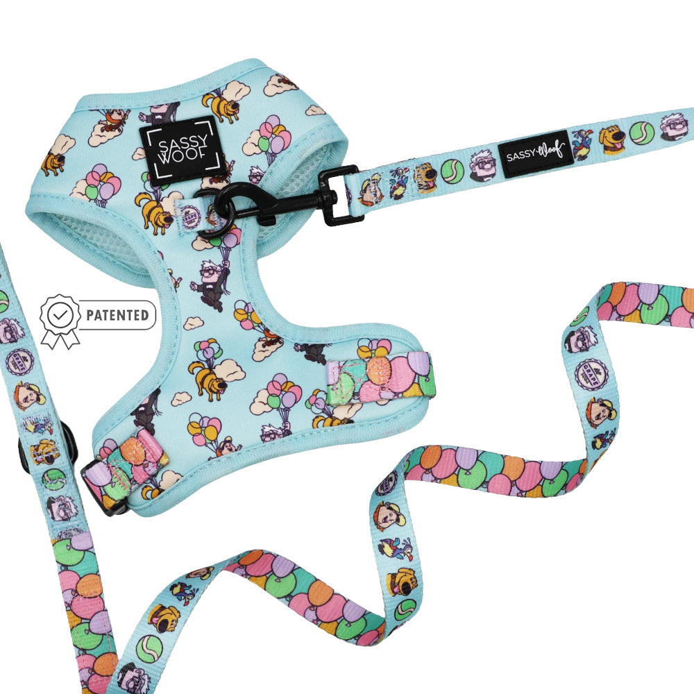The Sassy Woof Dog Two Piece Bundle - Disney and Pixar's Up features a light blue adjustable harness and matching leash with playful cartoon designs, a Sassy Woof label, and a patent badge icon for authenticity.