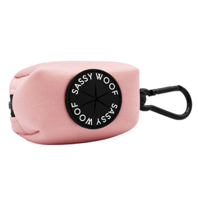 The Dog Three Piece Bundle - Dusty Rose by Sassy Woof includes a pink fabric waste bag holder with a black Sassy Woof patch and clip, perfect for attaching to your matching collar, leash, or bag on stylish walks.