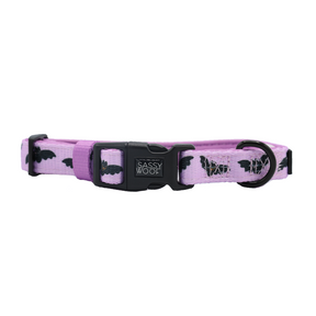 The Sassy Woof Collar - Lil Batty is an adjustable lavender dog collar adorned with black bats and white spider webs, featuring a sturdy metal D-ring for leash attachment and a black Sassy Woof-branded buckle.
