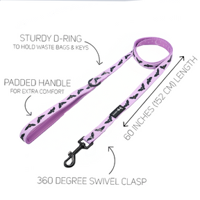 Part of our Fall dog collection, the Sassy Woof Dog Leash – Lil Batty in pink features an adorable black bat pattern, a sturdy D-ring, padded handle, 60-inch (152 cm) length, and a 360-degree swivel clasp. Perfectly pairs with your favorite bat dog harness or purple starry dog harness. Product features are labeled on a white background.