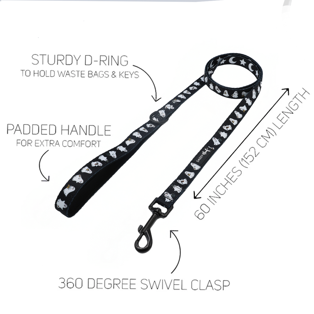 Introducing the Sassy Woof Dog Leash - Lil Boo Thing: a black leash adorned with white paw and bone designs, featuring a padded handle, sturdy D-ring, 60-inch (152 cm) length, and a 360-degree swivel clasp. Part of the Lil Boo Thing Dog Collection by Sassy Woof, this Halloween dog leash is displayed on a white background with arrows highlighting its features.