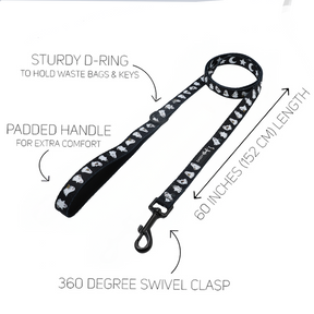 Black dog leash with white designs from the Sassy Woof Dog Two Piece Bundle - Lil Boo Thing, featuring a sturdy D-ring for bags and keys, a padded handle for comfort, 60-inch (152 cm) length, and a 360-degree swivel clasp. Pairs perfectly with the adjustable harness from the Lil Boo Thing collection. White text and arrows highlight each feature.