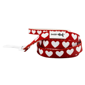 Red dog leash with white heart pattern and 'Sassy Dog' label on a white background