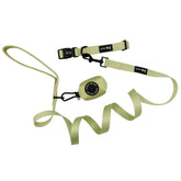 A light green retractable dog leash with black clasp, adjustable strap, handle loop, and Sassy Woof brand tag features a small round case labeled SAFETY WOOD. Pairs perfectly with the Matcha dog collar in the Dog Three Piece Bundle - Matcha.