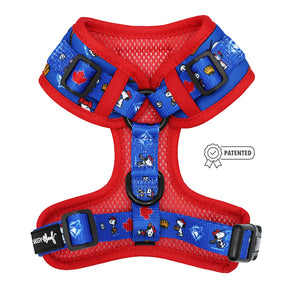 The Sassy Woof Dog Adjustable Harness - MLB™ x Peanuts™ Toronto Blue Jays™ features red and blue mesh, cartoon animal and maple leaf patterns, black buckles, and a patented design label on a white background.