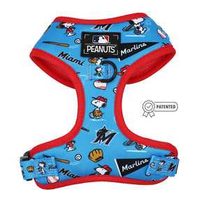 The Sassy Woof Dog Adjustable Harness - MLB™ x Peanuts™ Miami Marlins™ is blue with red trim, features Snoopy playing baseball with bats, gloves, and balls, and includes official MLB and Peanuts logos plus a patented badge for authenticity.