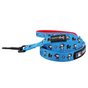 The Sassy Woof Dog Leash - MLB™ x Peanuts™ Miami Marlins™ features Snoopy in a red cap, team logos, and a black metal clasp. It matches perfectly with Peanuts Snoopy dog accessories.