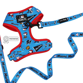 The Sassy Woof Dog Two Piece Bundle - MLB™ x Peanuts™ Miami Marlins™ is a blue and red Snoopy dog harness and leash set featuring Marlins icons, Peanuts characters, baseball motifs, and a PATENTED badge.