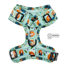 The Sassy Woof Dog Adjustable Harness - Disney's Merida features a teal design with black buckles, cartoon characters, orange-haired girls, floral patterns, and a patented icon displayed to the right of the harness.