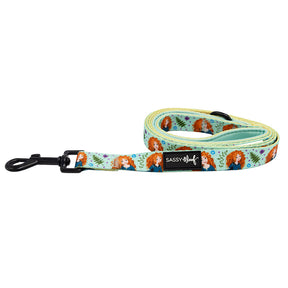 The Sassy Woof Dog Leash - Disney's Merida features rolled light blue material with floral patterns, red-haired Merida illustrations, a black metal clasp, and the SASSY Woof label.