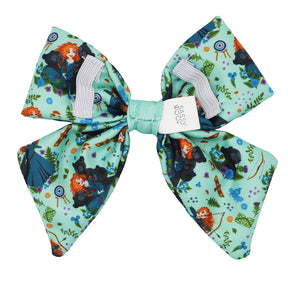 The Sassy Woof Dog Sailor Bow - Disney's Merida features a large mint green bow with cartoon characters, archery targets, forests, and bears, plus a white Sassy Woof tag at the center.