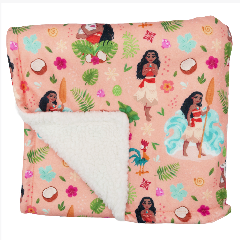 The Sassy Woof Pet Blanket - Disney's Moana features a peach sherpa design with a white fluffy underside, decorated with Moana, tropical leaves, coconuts, flowers, and a rooster—ideal for fans of Disney’s Moana dog gear.