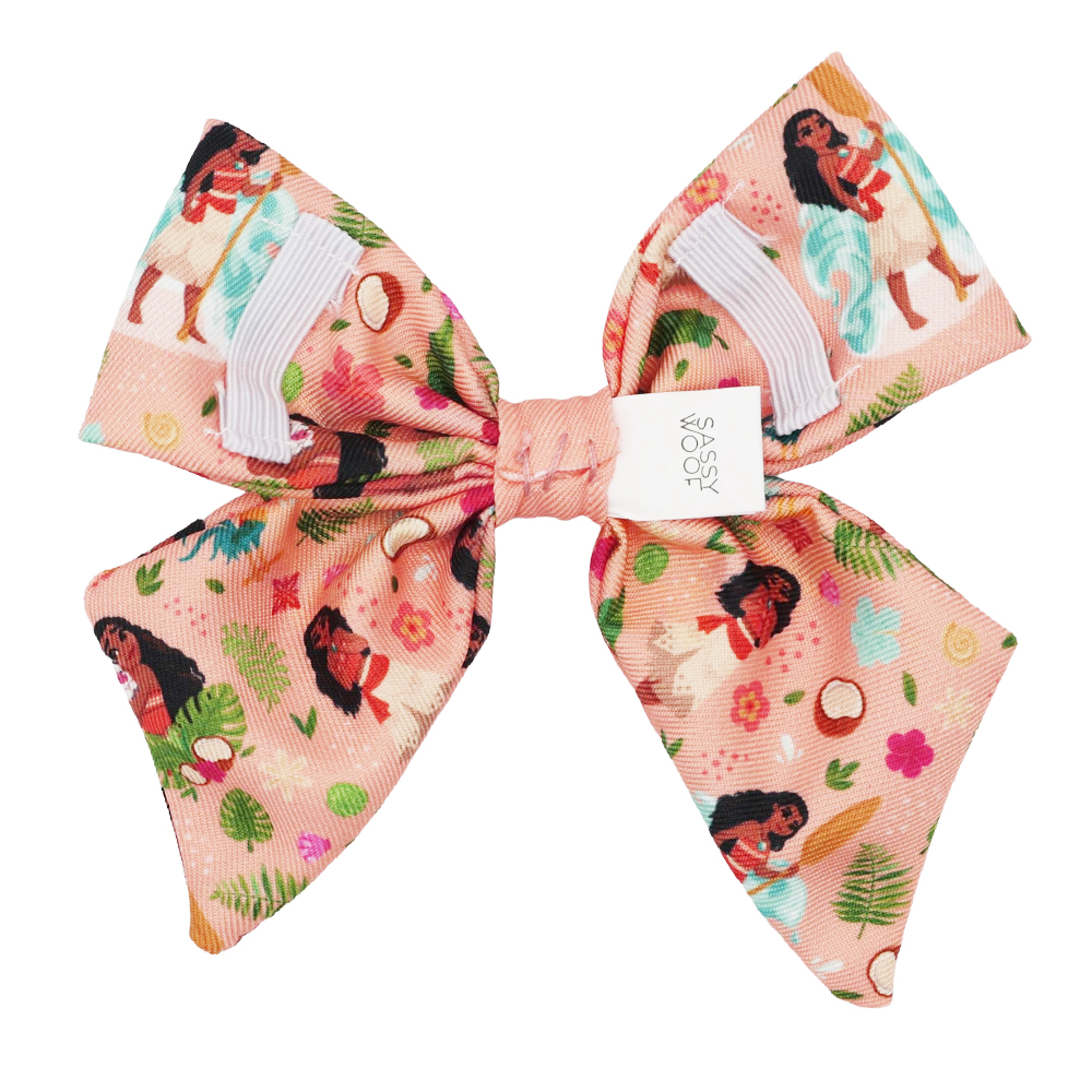 A pink Dog Sailor Bow by Sassy Woof, inspired by Disney's Moana, features white accents and colorful cartoon designs—ideal for fans of the Moana dog harness collection.