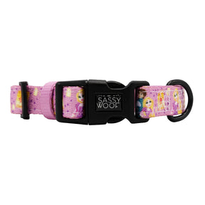 A pink adjustable Sassy Woof dog collar with cartoon designs and a black buckle featuring the brand name, part of the Harness Three Piece Bundle - Disney's Rapunzel collection.