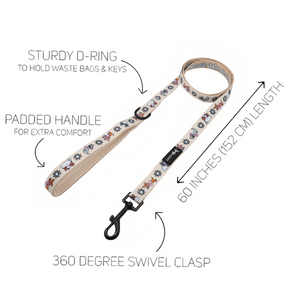 The Sassy Woof Dog Leash – Weenie Wonderland features a 60-inch (152 cm) beige leash adorned with paw and bone designs, a sturdy D-ring for keys or bags, padded handle for comfort, and a 360-degree swivel clasp—ideal for fans of pastel dog accessories.