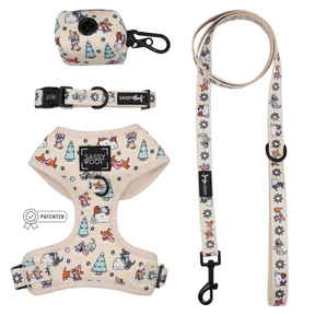 The Dog Four Piece Bundle - Weenie Wonderland by Sassy Woof features a beige adjustable dog harness adorned with cartoon winter animals, trees, and snowflakes. Perfect as a dachshund harness, this set includes a matching collar, leash, and waste bag holder—all featuring black clips and signature Sassy Woof branding.