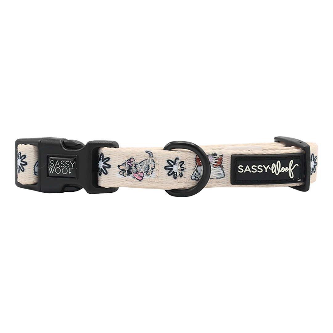 Add playful charm to your festive dog accessories collection with the Sassy Woof Dog Collar - Weenie Wonderland, featuring a cream-colored adjustable design, cartoon French bulldog faces, black hardware, and signature Sassy Woof labels on the clasp and strap.