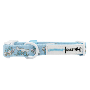 The Dog Collar - Cinnamoroll™ by Sassy Woof is light blue with white cartoon dogs, blue butterflies, a white plastic buckle, and a branded label. Pair it with the matching adjustable harness for extra style.