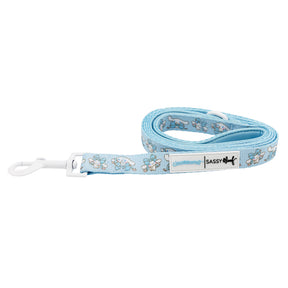 The Sassy Woof Dog Leash - Cinnamoroll™ is light blue with a white plastic clip, features cute bunny cartoons and a SASSY WOOF label—ideal for pairing with adjustable harnesses or other Sanrio accessories.