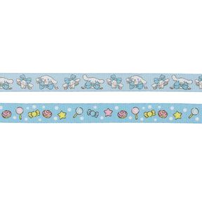This Dog Leash - Cinnamoroll™ by Sassy Woof features a white cartoon dog with blue bows on the top and colorful candies, lollipops, hearts, and stars on a blue polka dot background on the bottom—perfect for Sanrio fans!.