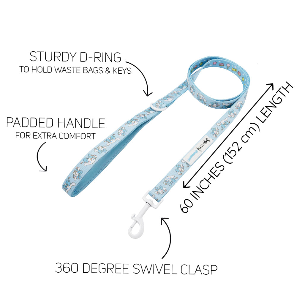 The Sassy Woof Dog Four Piece Bundle - Cinnamoroll™ features a light blue dog leash with cartoon prints, padded handle, sturdy D-ring for waste bags or keys, 60-inch length, and 360° swivel clasp. Arrows highlight each feature.