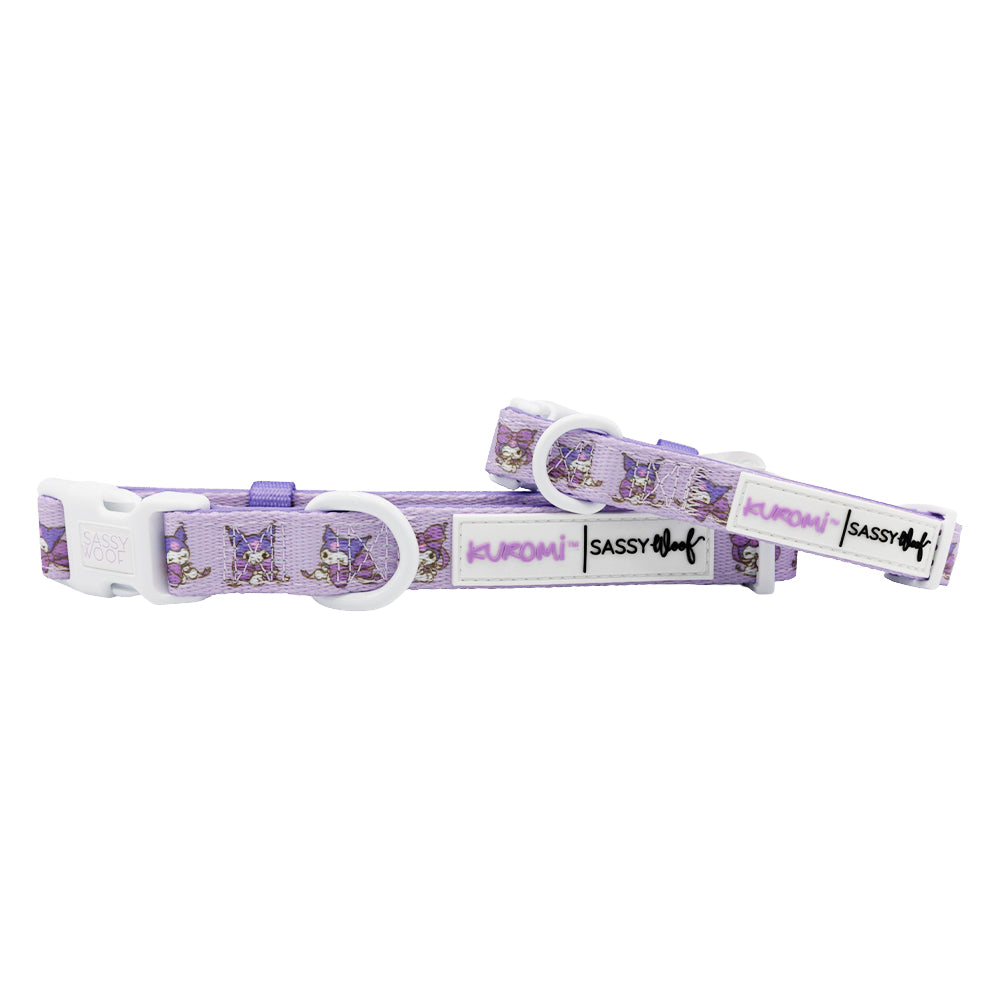 The Sassy Woof Dog Collar - Kuromi™ is a purple adjustable collar featuring cartoon Kuromi characters, a white plastic buckle and clips, plus KUROMI and SASSY patches—ideal for Hello Kitty fans.