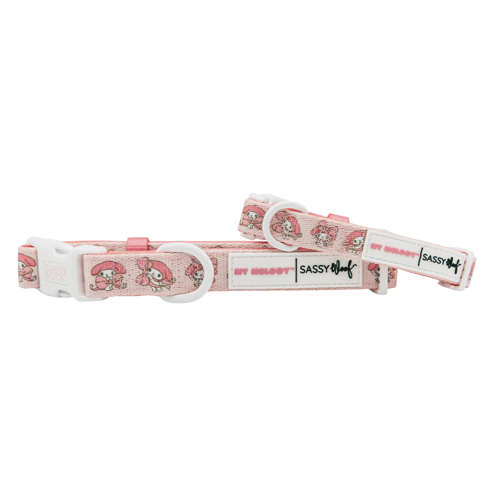 Two pink adjustable Sassy Woof dog collars with white plastic buckles and My Melody™ labels, featuring cute cartoon mushroom designs inspired by Hello Kitty.