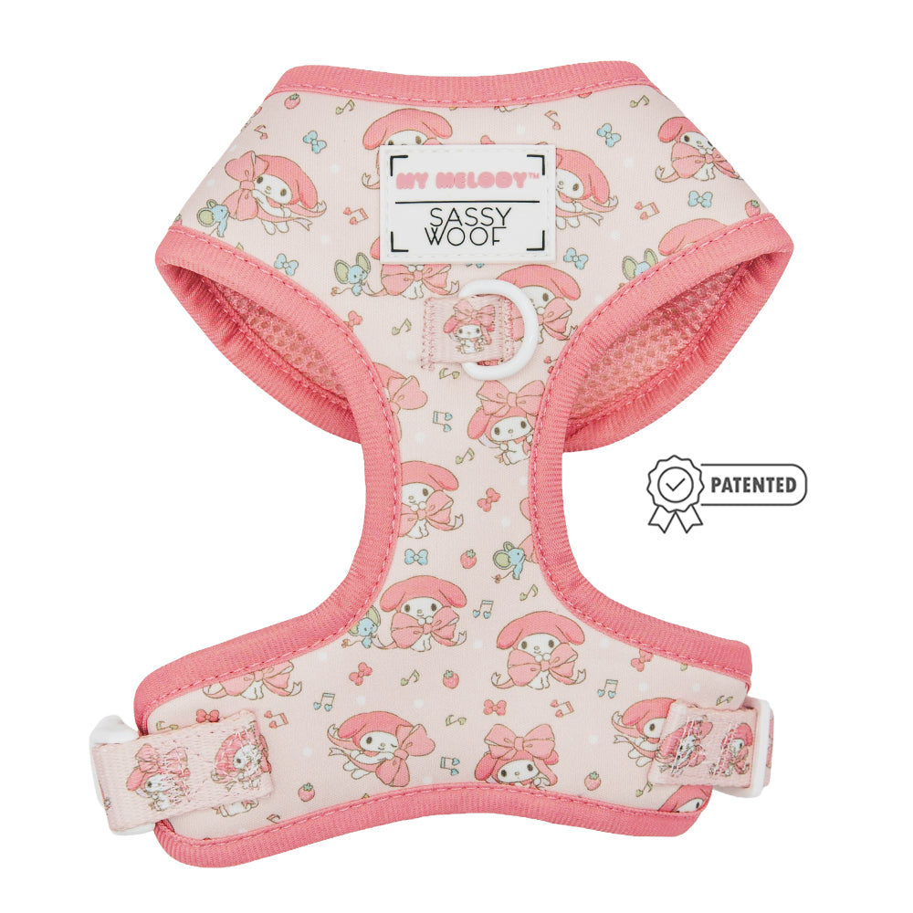 The Sassy Woof Dog Four Piece Bundle - My Melody™ is a pink dog harness with cartoon characters and bows, part of the Hello Kitty pet accessories collection. It showcases the Sassy Woof logo and a Patented badge on the right side.