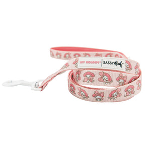 The Sassy Woof Dog Leash - My Melody™ is pink, features repeated My Melody designs, a white plastic clip, and a Sassy Woof label.