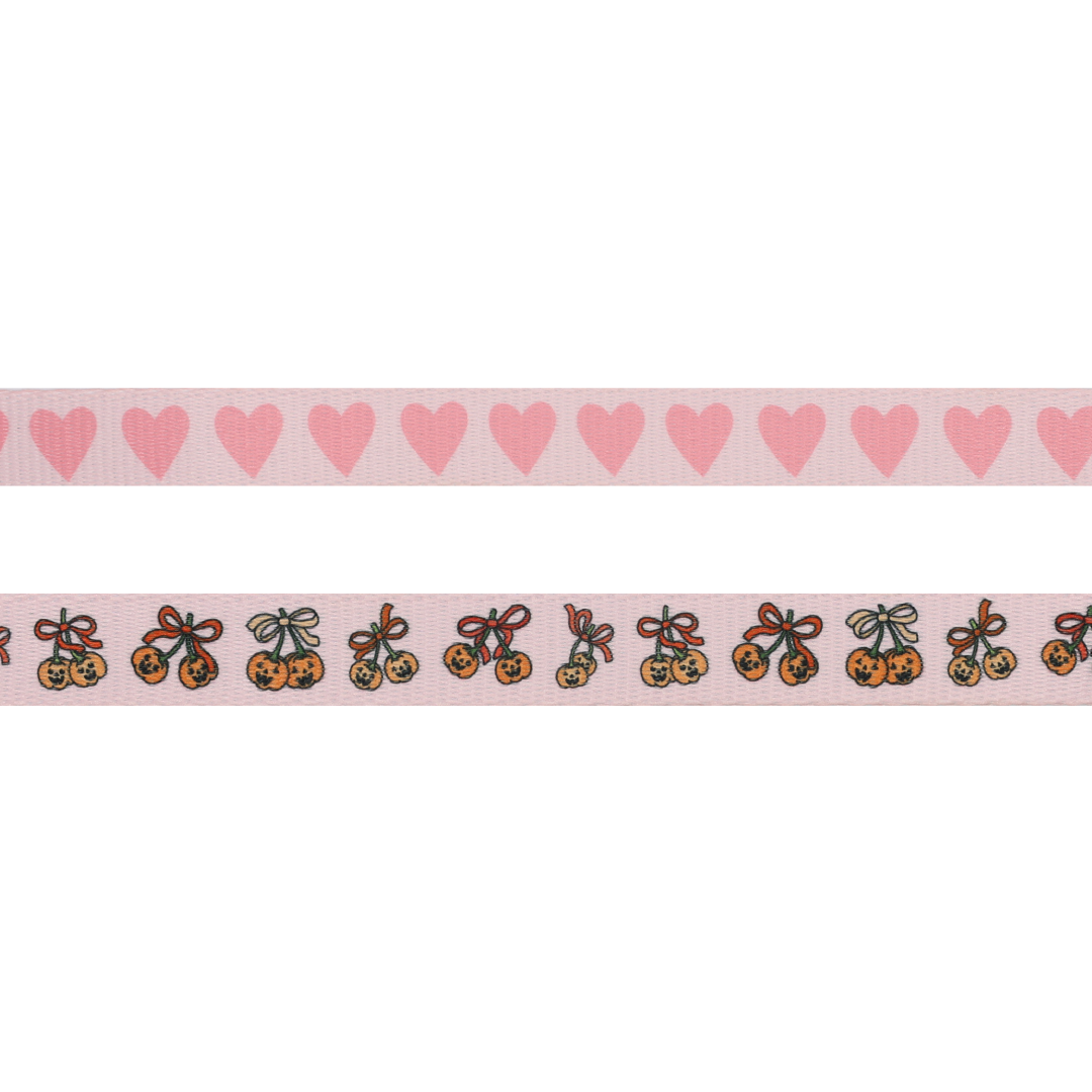 Two pink ribbons: the top ribbon is adorned with a row of solid pink hearts, while the bottom features charming orange pumpkins with bows, evenly spaced along its length—an adorable choice to complete your Sassy Woof Dog Leash - Sassy Lil Pumpkins collection.