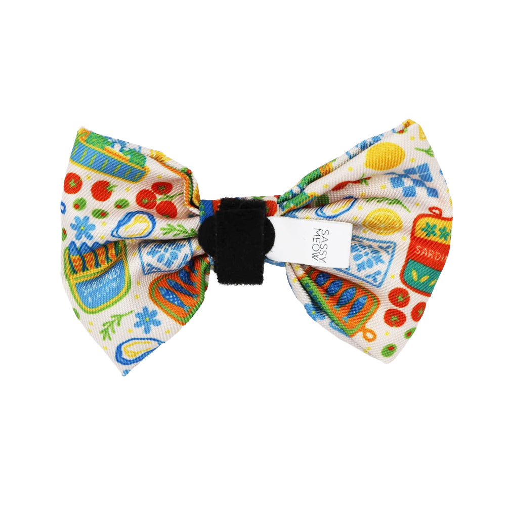 The Sassy Woof Cat Bowtie - Portofino showcases a vibrant kitchen-themed print on white with a black center band, ideal for adding playful flair to any lightweight cat collar or harness.