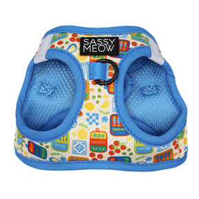 The Cat Step-In Harness - Portofino by Sassy Woof features blue trim, breathable mesh, and colorful sardine can, lemon, and pattern designs. A Sassy Meow label sits at the top with a metal ring below.