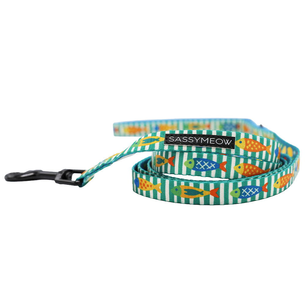 The Cat Leash - Portofino by Sassy Woof features a blue and green fish pattern, black clasp, and SASSYMEOW label. Perfectly pairs with a lightweight harness for stylish cat walks.