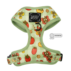 The Sassy Woof "Feeling Vine" Dog Adjustable Harness features a green plaid, plant-inspired design with tomato and slice patterns, a black Sassy Woof label on the front, PATENTED badge icon on the side, and adjustable straps for comfort.