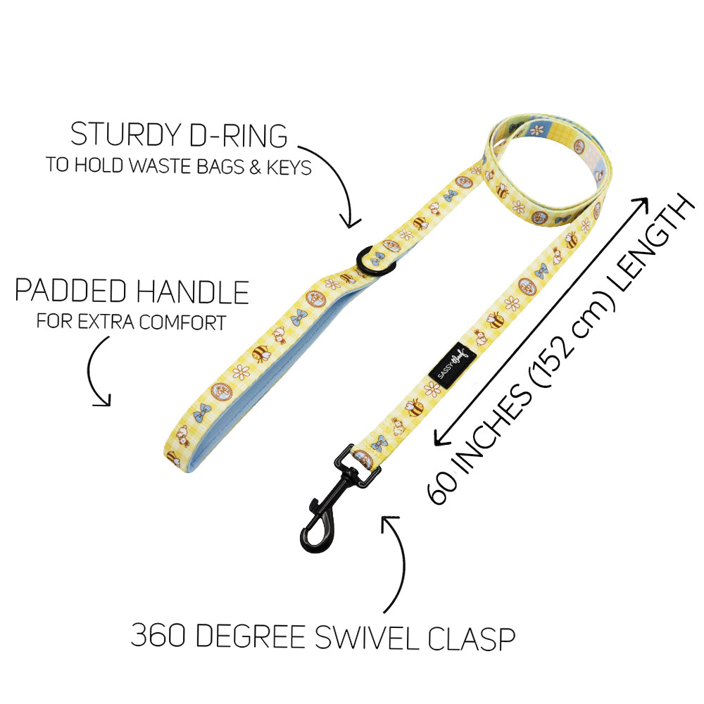 The Sassy Woof Dog Four Piece Bundle - Patch Perfect features a yellow cartoon-print leash with padded handle, sturdy D-ring, 360° swivel clasp, and 60-inch length—each feature highlighted in text.