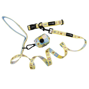 The Sassy Woof Dog Three Piece Bundle - Patch Perfect features a playful bee and flower picnic pattern in yellow and blue, with black clasps and signature tags—perfect for stylish pups! Includes a matching leash, collar, and waste bag holder.