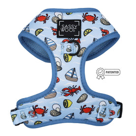 The Sassy Woof Dog Adjustable Harness - Coastal Cuties features a blue nautical design with red crabs, sailboats, seashells, adjustable fit, and a patented badge icon on the right.