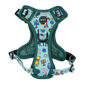 The Sassy Woof Dog Step-in Harness features Disney’s Winnie the Pooh designs, with cartoon Pooh characters, honey pots, and forest elements on a teal background. A round black Sassy Woof tag is visible near the top.
