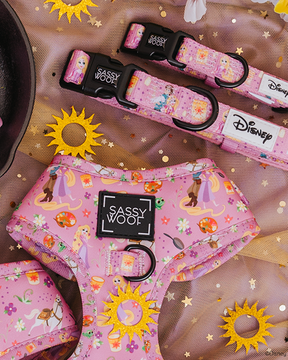 The Sassy Woof Dog Collar - Disney's Rapunzel, featuring Tangled-inspired designs with Rapunzel and florals, is displayed on gold star and sun-patterned fabric.