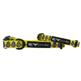 Two yellow Dog Collar - Wonder Woman™ by Sassy Woof, featuring Wonder Woman logos, black plastic buckles, metal rings, soft neoprene construction, and a black label with DC, Wonder Woman™, and Sassy Woof logos.