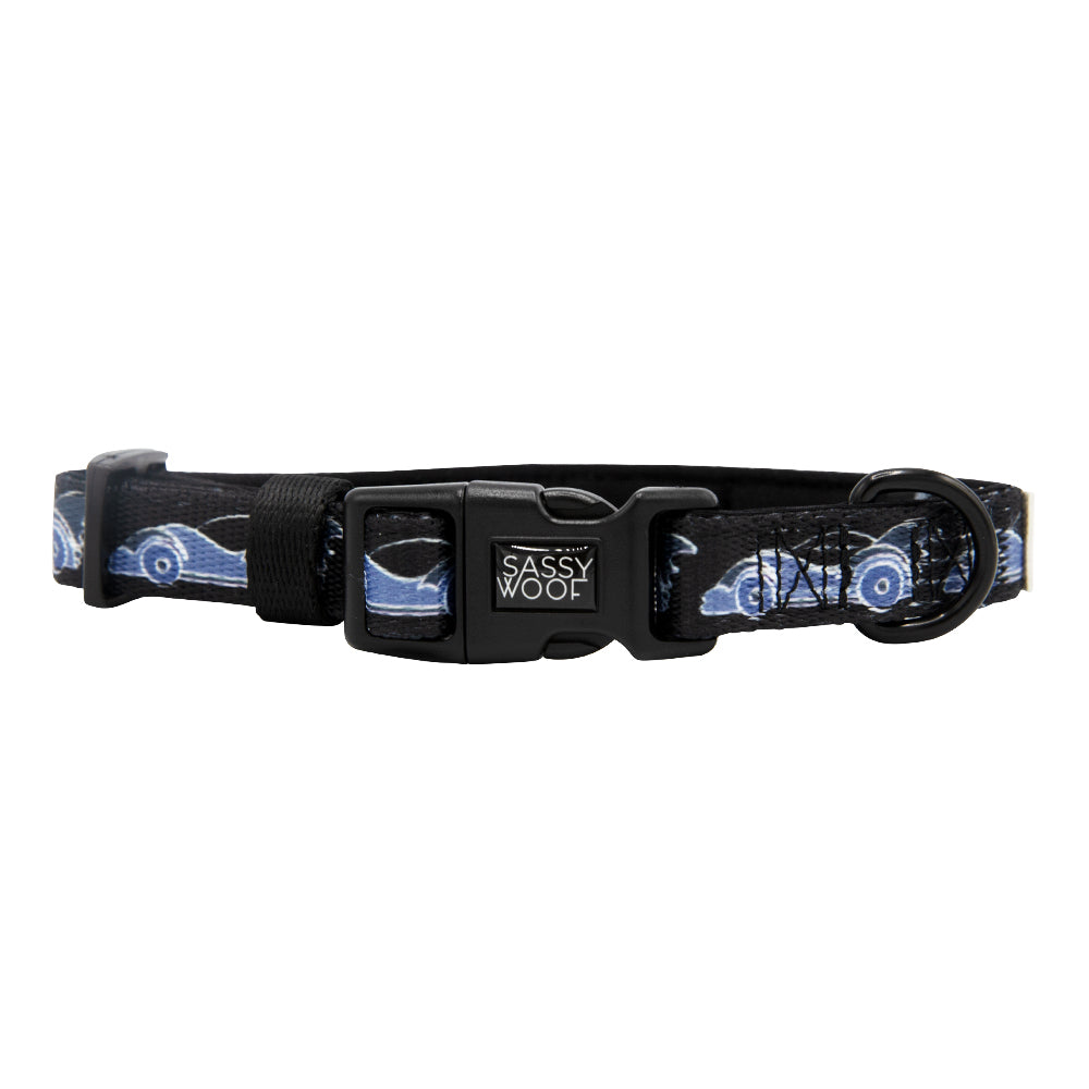 Black dog collar with a black buckle, sturdy metal ring, and a repeating Batman™ design. The collar features the Sassy Woof logo on the buckle and is part of the exclusive DC x Sassy Woof Dog Collar Three Piece Bundle - Batman™. Pair it with your favorite dog leash for ultimate superhero style.