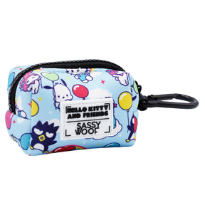 The Dog Waste Bag Holder - Hello Kitty® & Friends In the Sky by Sassy Woof is a small blue zippered holder adorned with balloons and Sanrio characters, featuring a black clip and pet accessory labels.