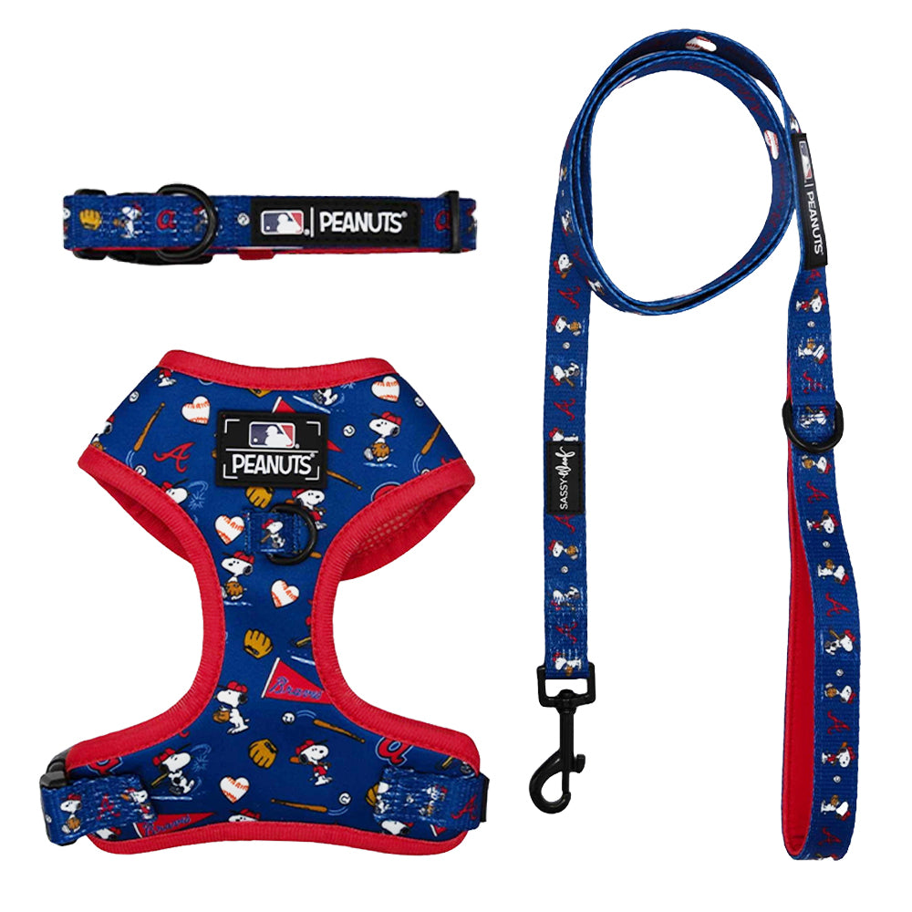 The Sassy Woof Harness Three Piece Bundle - MLB x Peanuts™ Atlanta Braves™ features blue and red dog harness, collar, and leash with Snoopy and team logos. The adjustable harness ensures comfort for your pup’s growth.
