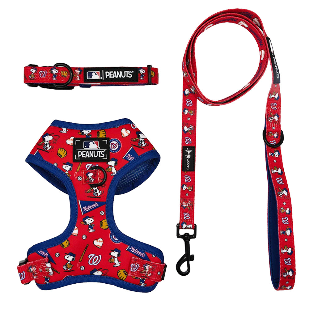 The Sassy Woof Harness Three Piece Bundle - MLB x Peanuts™ Washington Nationals™ features a red adjustable harness, collar, and leash with Snoopy designs and blue trim—perfect for fans. Displayed on a white background.