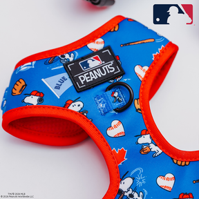 The Sassy Woof Dog Adjustable Harness - MLB™ x Peanuts™ Toronto Blue Jays™ features Snoopy, baseballs, bats, and gloves on a white background with blue and red trim, plus Peanuts and Major League Baseball logos.