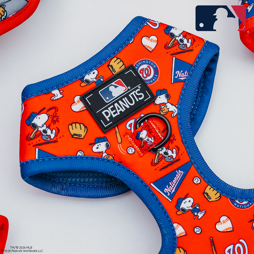 The Sassy Woof Dog Adjustable Harness - MLB x Peanuts™ Washington Nationals™ features Snoopy graphics and team logos in red and blue, displayed on a white background.